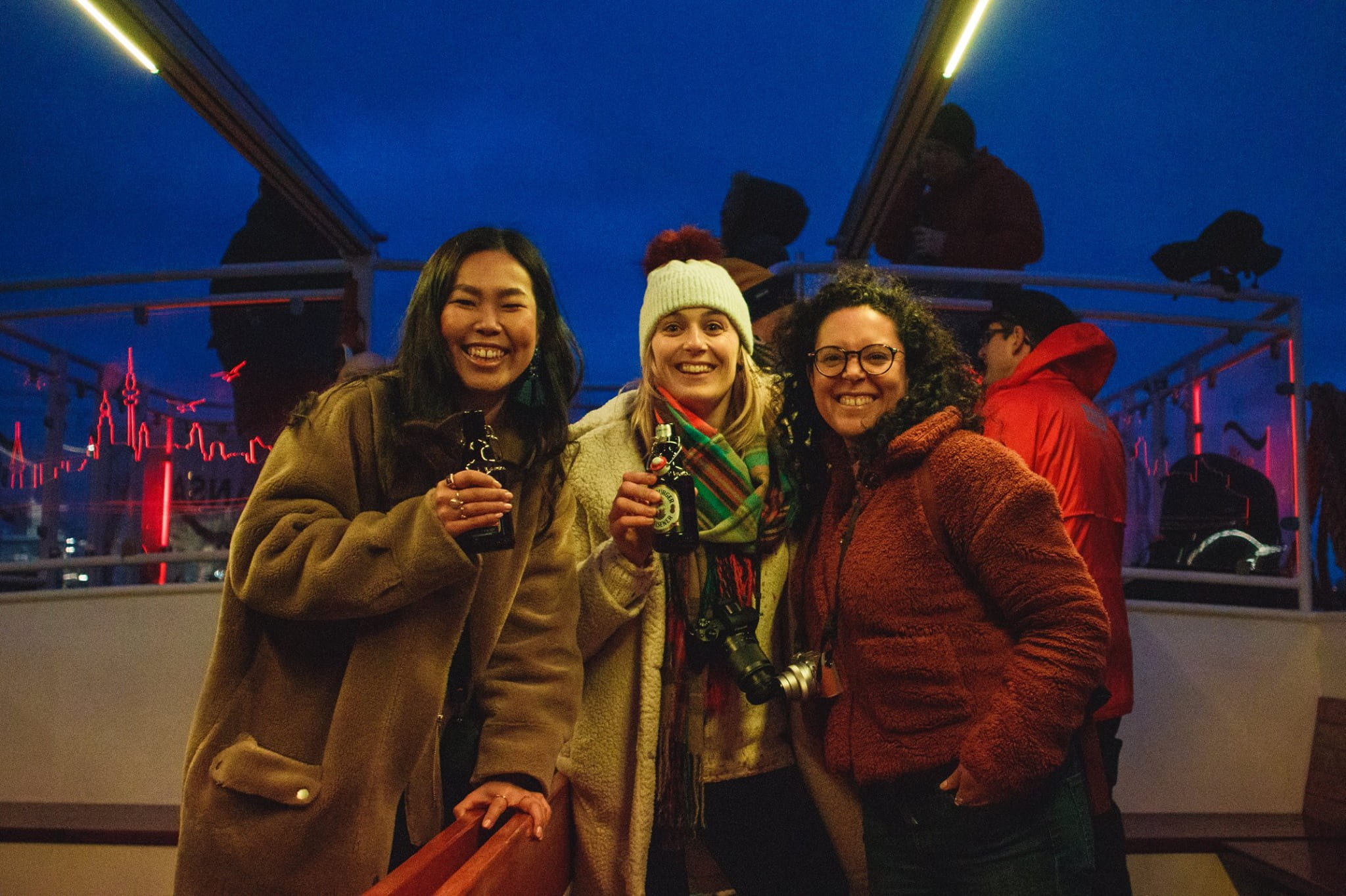 Three girls stood on a boat from KeyFrame having a drink