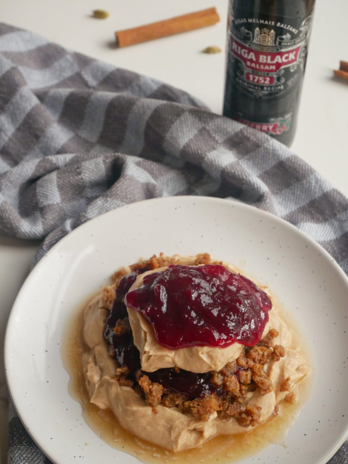 typical Latvian dish of rye bread dessert with bottle of traditional Latvian drink Riga Black Balsam behind it