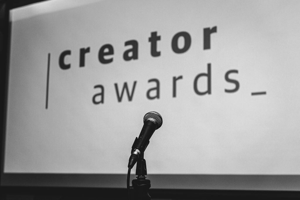 Traverse Creator Awards logo on a screen and microphone on stage
